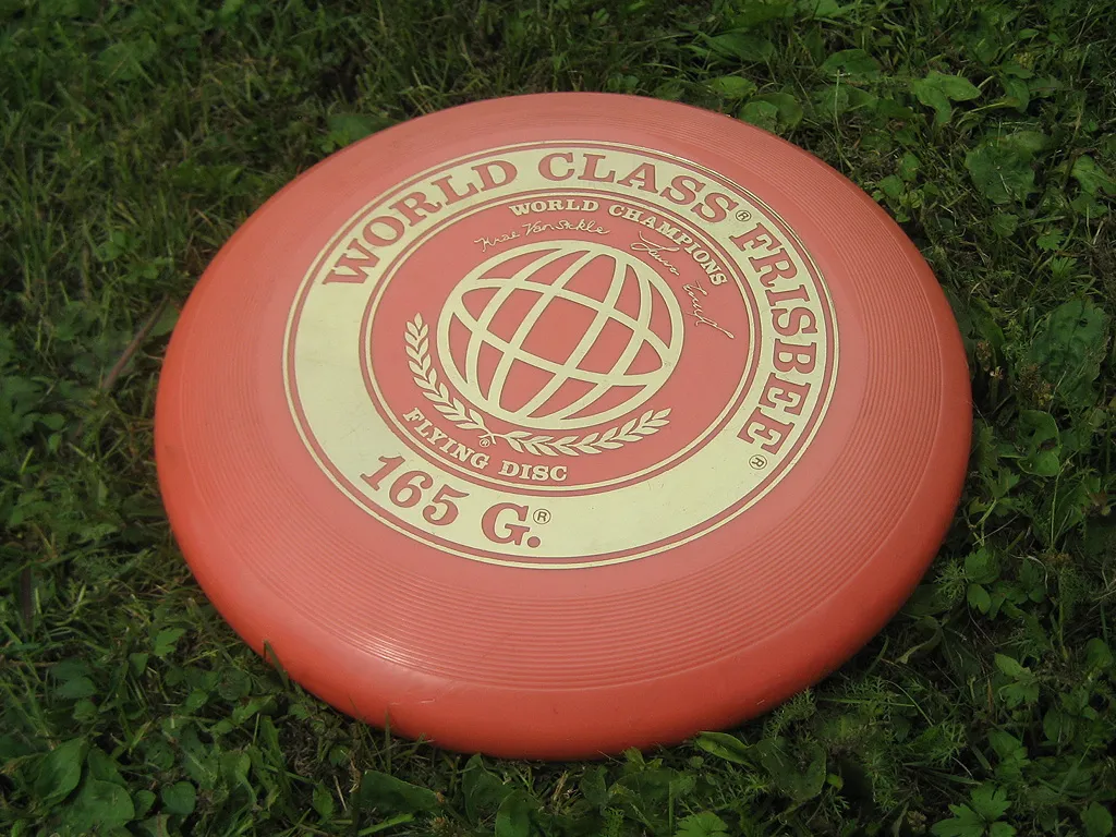 Un disque volant frisbee en plein vol illustrant l'aerodynamisme et les sports de disque