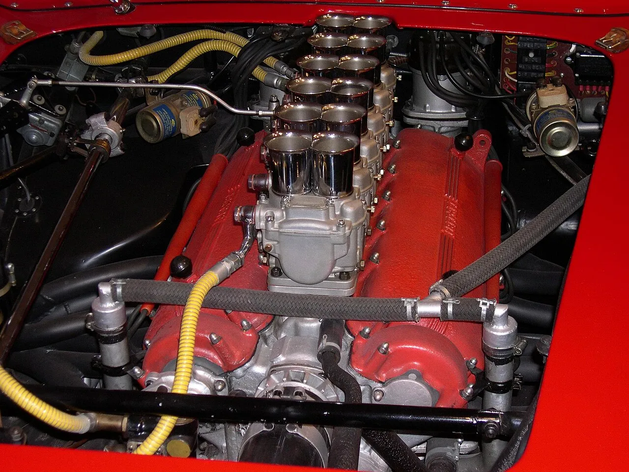 Le mythique moteur Ferrari Colombo V12 exposé sous le capot d'une sportive classique